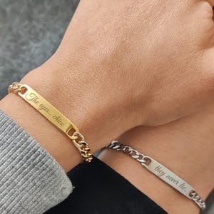 Puede incluir: Dos pulseras de cadena. Una es dorada con la inscripción "The eyes.. chico" y la otra es plateada con la inscripción "they never lie."