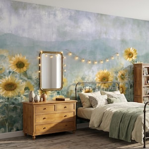 Könnte beinhalten: Ein Schlafzimmer mit einem Wandbild mit Sonnenblumen, einem Metallbettrahmen, einer Holzkommode und einem Bücherregal. Der Raum ist mit einem goldgerahmten Spiegel und Lichterketten dekoriert, was eine warme Atmosphäre schafft.