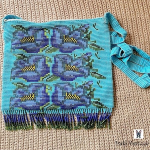 May include: A turquoise beaded handbag with a floral design in shades of blue, green, and yellow. The bag features a long strap and a fringe along the bottom. The bag is made of small beads and has a zipper closure.