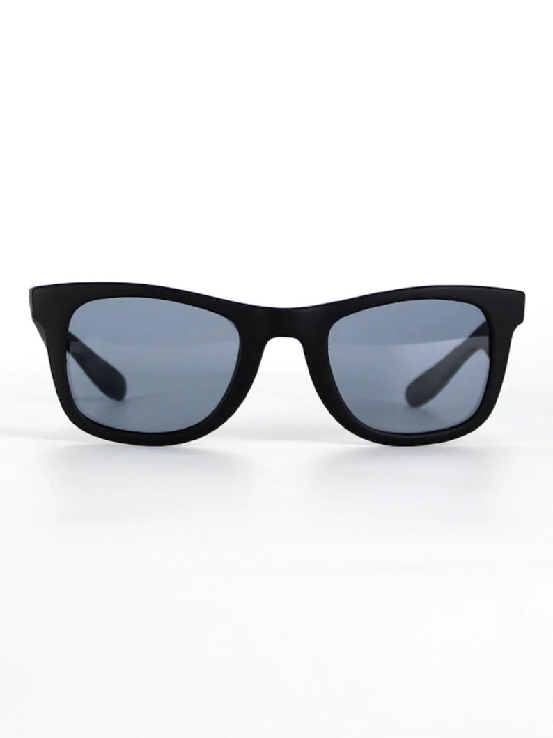 May include: Black sunglasses with a square frame and dark gray lenses.