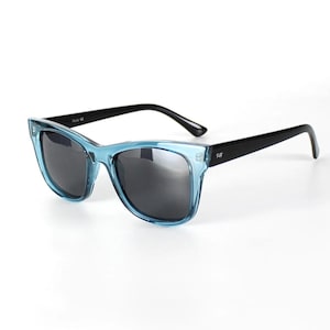 May include: Blue and black sunglasses with a square frame. The sunglasses have a gradient blue frame and black arms.
