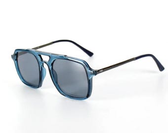 May include: Blue tinted aviator sunglasses with a dark gray lens and a silver metal frame.