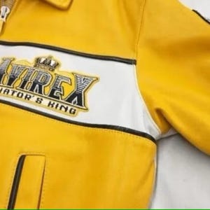 May include: Yellow leather jacket with white stripe detail and the text "AVIREX AVIATOR'S KING" on the chest. Features a zipper closure and a small pocket. The jacket has a classic, sporty design.