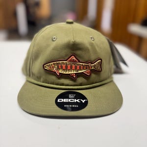May include: Olive green baseball cap with a fish patch. The patch features a detailed illustration of a fish in shades of red, orange, and brown. The cap has a curved brim and a black and white "DECKY ORIGINAL" sticker.