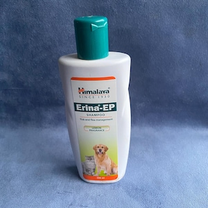 May include: White Himalaya Erina-EP shampoo bottle with a teal cap. The label features a dog and cat illustration, the text "Lemon Fragrance", and "Tick and flea management". The bottle contains 200 ml of shampoo.