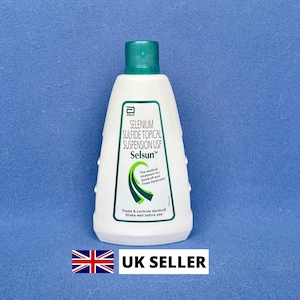 Może przedstawiać: Biała butelka szamponu przeciwłupieżowego Selsun z zieloną nakrętką. Etykieta zawiera tekst "SELENIUM SULFIDE TOPICAL SUSPENSION USP" i "Treats & controls dandruff". Butelka znajduje się na niebieskim tle.