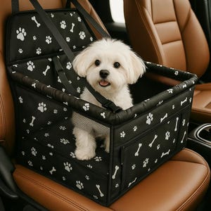 May include: A black and white patterned pet car seat with a white dog sitting inside. The seat has a mesh panel and a zippered pocket.