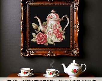 Puede incluir: Un patrón de punto de cruz enmarcado de una tetera vintage adornada con rosas rojas y hojas verdes sobre un fondo negro. El marco es ornamentado, con un acabado marrón oscuro. Debajo, una tetera blanca y dos tazas de té con diseños de rosas.
