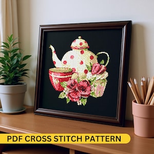 May include: Framed cross-stitch art featuring a teapot, teacup, and flowers on a black background. The teapot is cream-colored with red polka dots. The teacup and flowers are red and pink. The frame is dark brown. The text "PDF CROSS STITCH PATTERN" is at the bottom.