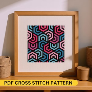 May include: A framed cross-stitch pattern featuring a geometric design of interlocking hexagons in shades of pink, blue, and black. The text "PDF CROSS STITCH PATTERN" is displayed on a yellow banner at the bottom of the frame.