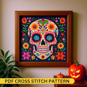 May include: A framed cross-stitch pattern with a colourful skull design and floral accents. The skull is decorated with vibrant flowers in shades of orange, pink, yellow, and blue. The text "PDF CROSS STITCH PATTERN" is displayed at the bottom.