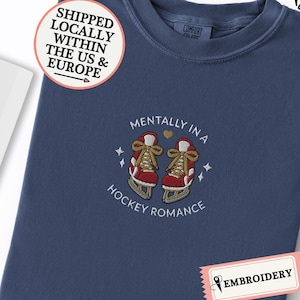 Può includere: Una tazza di ceramica bianca con manico nero e la scritta "But First, Coffee" in nero, in grassetto. La tazza è appoggiata su una superficie di legno. La tazza è alta circa 10 cm.