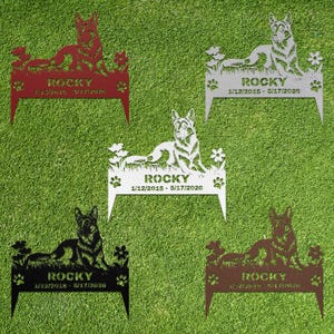 May include: Five metal garden stakes featuring a German Shepherd dog silhouette lying in grass with flowers. Each stake displays the name ROCKY and the dates 1/12/2015 - 5/17/2026, with paw prints on the sides. Available in red, silver, white, black, and brown.