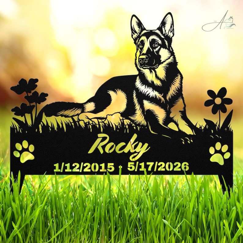 May include: A black metal garden stake featuring a German Shepherd dog lying down, flanked by flowers and paw prints. The text reads Rocky, 1/12/2015, and 5/17/2026. The design is cut from a single piece of dark metal with a flat, silhouette style.