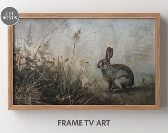 May include: A framed painting of a brown rabbit sitting in a field of tall grass. The background is a soft, muted blue and green, with a hazy, atmospheric effect. The rabbit is looking to the left, with its ears perked up.