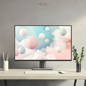 Puede incluir: Una configuración de escritorio moderna con un monitor de computadora que muestra un fondo abstracto colorido con esferas de colores pastel flotando en un cielo nublado. El monitor está sobre un escritorio de madera clara con un teclado blanco y un ratón blanco.