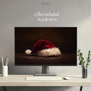 以下が含まれることがあります： 暗い茶色の背景に、白い毛皮の縁取りが付いた赤いサンタ帽子のデジタルイラストが表示されたコンピュータモニター。画像の上に「2つのファイルが含まれています: 16x9 & 16x10」というテキストが表示されています。