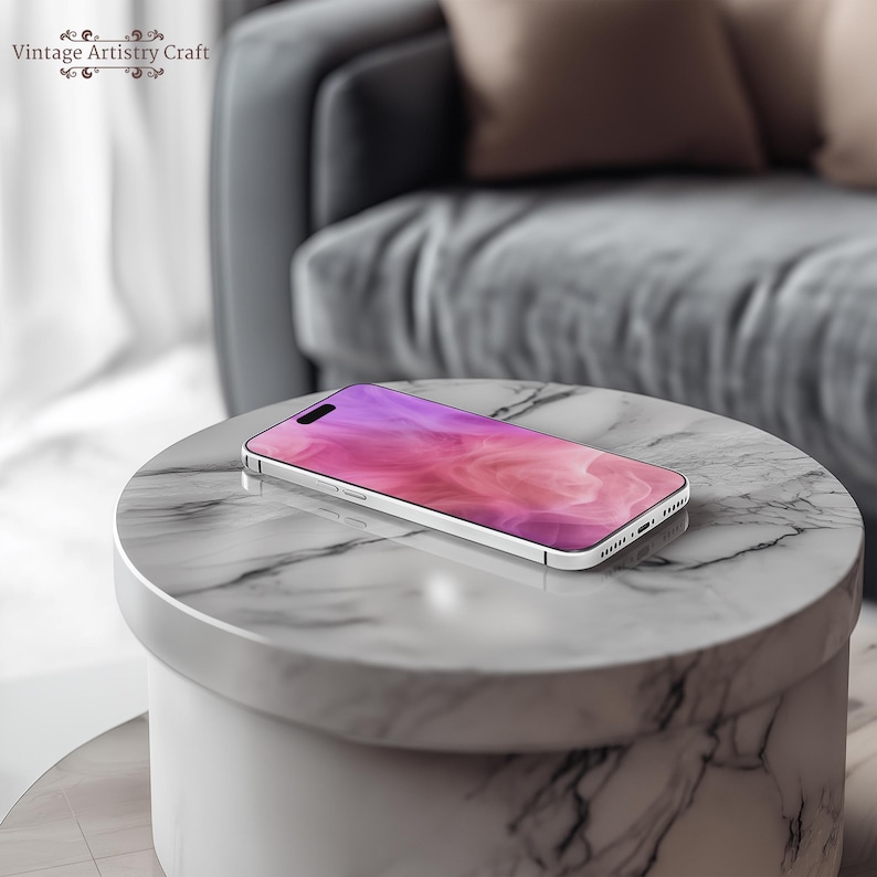 May include: A white smartphone with a pink and purple abstract design on the screen. The phone is lying on a white marble surface.