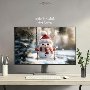 May include: A digital illustration of a snowman wearing a red and white hat and scarf, sitting on a swing in a snowy forest. The image is displayed on a computer monitor.