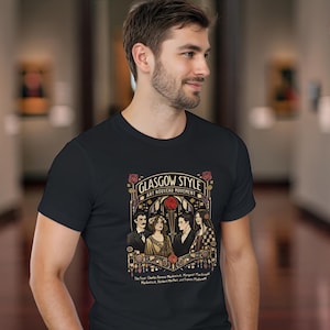 Puede incluir: Camiseta negra con un dise&ntilde;o gr&aacute;fico de estilo vintage. El dise&ntilde;o presenta el texto "Glasgow Style Art Nouveau Movement" e ilustraciones de personas y rosas. La camiseta la lleva una persona.