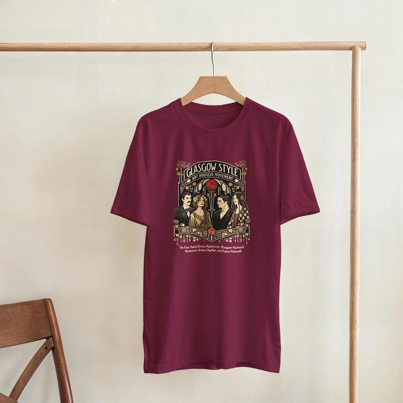 Puede incluir: Camiseta burdeos con un dise&ntilde;o gr&aacute;fico de estilo Art Nouveau que representa cuatro figuras. El texto "Glasgow Style Art Nouveau Movement" est&aacute; encima de la imagen. Debajo, hay texto con nombres.