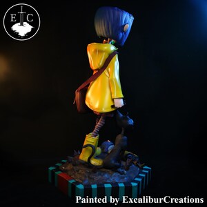 May include: A figurine of a character from the animated film, wearing a yellow raincoat, blue hair, and boots. The figure is standing on a colorful base with a black cat. The text "Painted by ExcaliburCreations" is at the bottom.