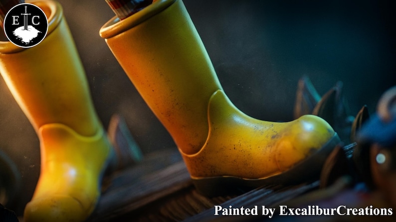 May include: Close-up of two yellow boots with a worn, textured appearance. The boots are set against a dark background, with the text "Painted by ExcaliburCreations" at the bottom. The boots appear to be made of a durable material.