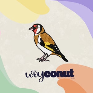 Puede incluir: Parche bordado de un pájaro amarillo y marrón con la cabeza roja, sobre un fondo blanco. El texto "THE WOYCONUT SHOP" está debajo del pájaro.