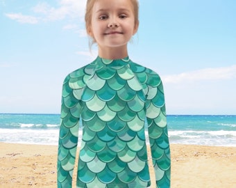 Maglietta protettiva anti-UV per bambini, ideale per nuoto e protezione solare, con fantasie personalizzate uniche.