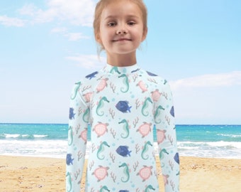 Maglietta protettiva anti-UV per bambini, ideale per nuoto e protezione solare, con fantasie personalizzate uniche.