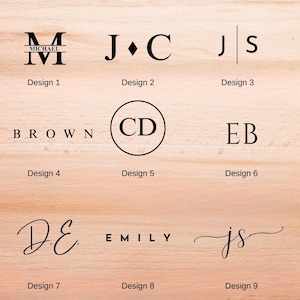 May include: Nine different monogram designs in black font are displayed on a light wood surface. The designs include initials, names, and a circular design. Each design is labeled with a number.