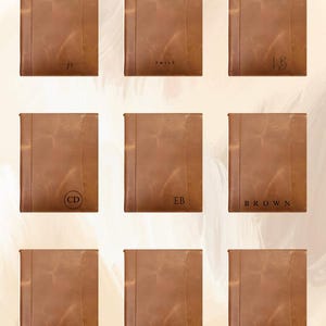 May include: Nine brown leather journals with personalized initials or names. Each journal has a vertical seam on the left side. The initials or names are in black. The journals are arranged in a grid pattern.