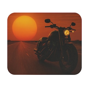 May include: A motorcycle silhouetted against a sunset. The bike is on a long, straight road with a large orange sun in the background. The motorcycle has a large front tire and a round headlight.