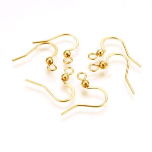 Może przedstawiać: Sześć złotych haczyków do kolczyków z małą kulką na górze każdego haczyka.