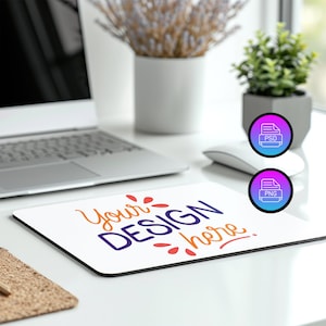 Può includere: Tappetino per mouse bianco con il testo "Your Design Here" in lettere colorate. Il tappetino per mouse è su una scrivania bianca con un laptop, una pianta in vaso e un mouse bianco.