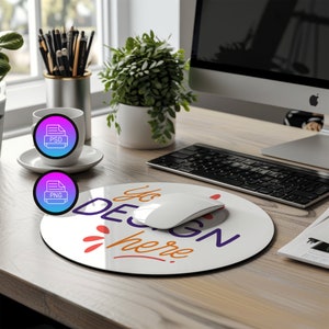 May include: A white round mouse pad with a black border. The mouse pad has the text "You Design Here" in orange and purple lettering with a stylized orange and white flame design. A white wireless mouse is on top of the mouse pad.