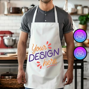 Pode incluir: Um avental branco com o texto "Your DESIGN here" em laranja e roxo. O avental tem alças brancas. Dois ícones para arquivos PSD e PNG estão no fundo. O avental está sendo usado.