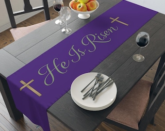 Camino de mesa de Pascua con texto "He Is Risen" en salvia, morado, decoración cristiana