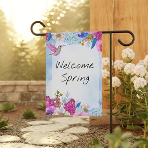 May include: A welcome spring garden flag with a hummingbird, flowers, and the text "Welcome Spring".