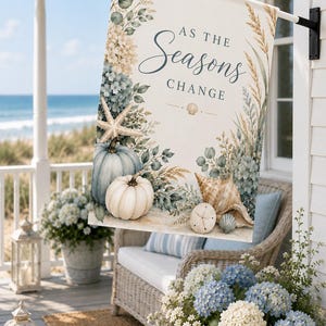 以下が含まれることがあります： AS THE Seasons CHANGEという濃い青色の文字が書かれた長方形のガーデンフラッグ。青と白のカボチャ、ヒトデ、貝殻、乾燥した草、緑の葉のイラストがクリーム色の背景に描かれています。