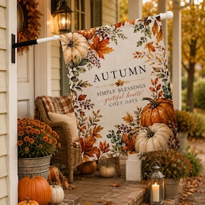 May include: A rectangular garden flag featuring a cream-coloured background with a border of autumn leaves and pumpkins. The text reads AUTUMN, SIMPLE BLESSINGS, grateful hearts, and COZY DAYS in black and brown lettering on the fabric surface.