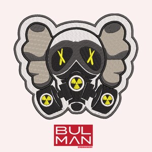 Pode incluir: Etiqueta bordada com um personagem de desenho animado usando uma máscara de gás com um design de caveira e ossos cruzados. O personagem tem orelhas grandes e um esquema de cores cinza e branco. A máscara de gás é preta com detalhes amarelos. A etiqueta é cercada por uma borda branca.