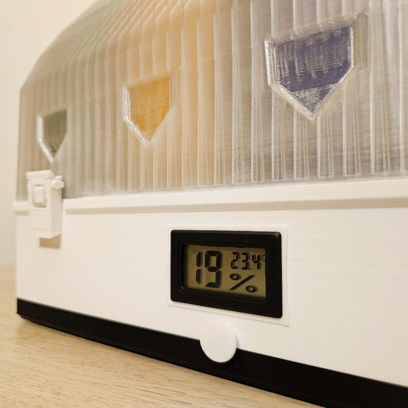 4‑spool modular 3D‑printed drybox with clear front windows and humidity and temperature display.