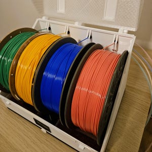 Four filament spools loaded inside the drybox, ready for multi‑color printing.