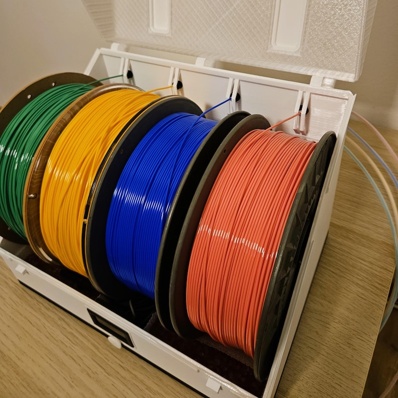 Four filament spools loaded inside the drybox, ready for multi‑color printing.