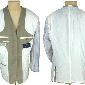 May include: A tan blazer displayed on a mannequin, showcasing the interior construction. The jacket features a white lining, striped sleeves, and two small labels. The back view reveals the lining and construction details.