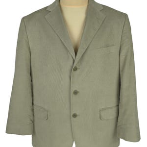 May include: A light green blazer with a three-button closure, a notched lapel, and two front pockets. The blazer is displayed on a mannequin and has a classic, tailored design. The fabric appears to be a lightweight material, suitable for warmer weather.