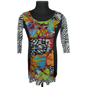 May include: A black, long-sleeved dress with a vibrant butterfly print on the front. The dress features a scoop neckline and zebra-striped sleeves. The butterfly design incorporates shades of red, yellow, blue, and green.