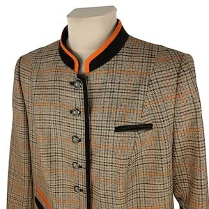 May include: A brown and black plaid blazer with a black and orange collar. The blazer has a black trim and silver buttons.