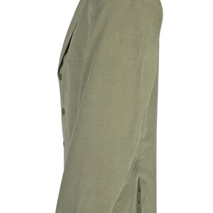 May include: A light green corduroy blazer displayed on a mannequin. The blazer has a notched lapel, three buttons on the sleeve cuffs, and two buttons on the front. The fabric has a vertical ribbed texture.